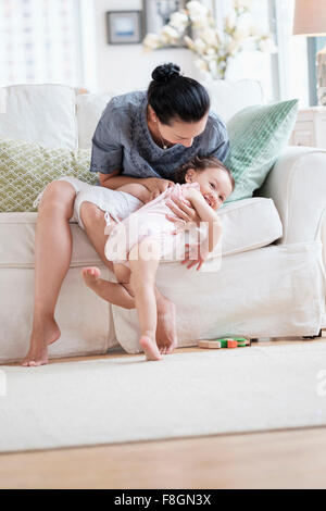 Mutter mit Tochter auf Sofa spielen Stockfoto