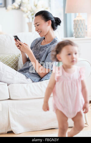 Mutter mit Handy ignorieren Baby Tochter Stockfoto
