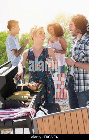 Frau serviert Würstchen zu grillen Stockfoto