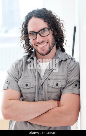 Kaukasischen Mann lächelnd mit verschränkten Armen Stockfoto