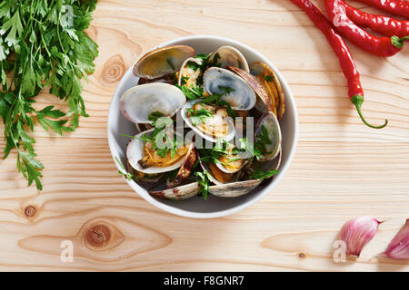 Gedämpfte Muscheln in weiße Schüssel auf Holztisch Stockfoto