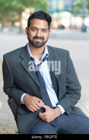 Indischer Geschäftsmann sitzen auf Bank in Stadt Stockfoto