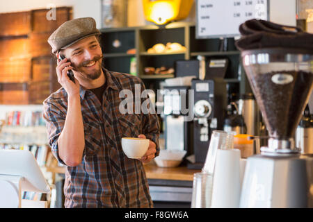 Kaukasischen Mann reden über Handy im café Stockfoto