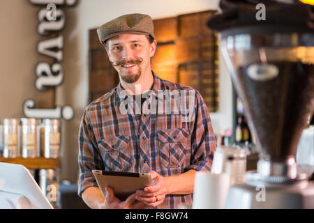 Kaukasische Barista hält digitale Tablet im café Stockfoto