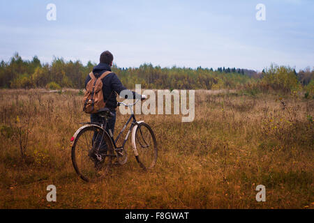 Kaukasischen Mann Feld Fahrrad einschieben Stockfoto