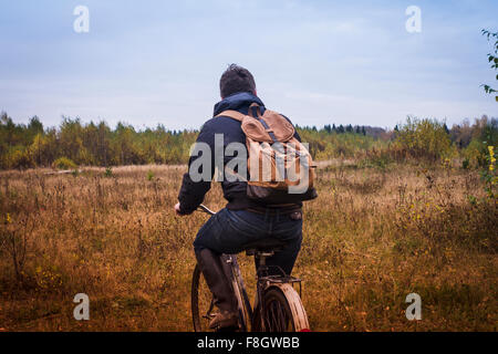 Kaukasischen Mann Reiten Fahrrad im Feld Stockfoto