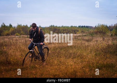 Kaukasischen Mann Reiten Fahrrad im Feld Stockfoto