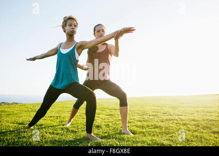 Lehrer helfen Schüler Praxis Yoga im freien Stockfoto