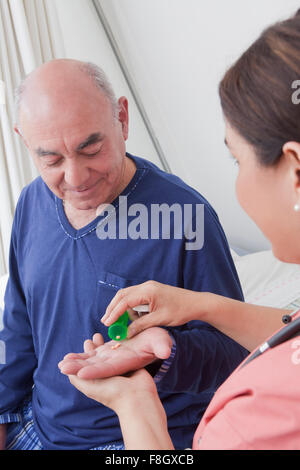 Hispanische Krankenschwester geben Patienten Medikamente Stockfoto