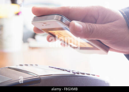 Hispanic Frau Kreditkarte von Handy Scannen Stockfoto