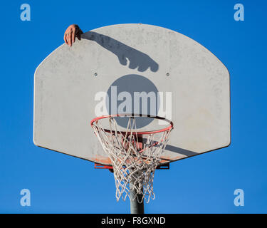 Kaukasischen Mann dunking Basketball Schatten in Reifen Stockfoto