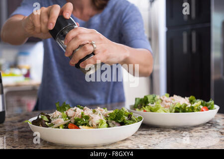 Gemischte Rassen Frau würzen Salat Stockfoto