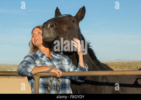 Kaukasische Rancher lächelnd mit Pferd Stockfoto