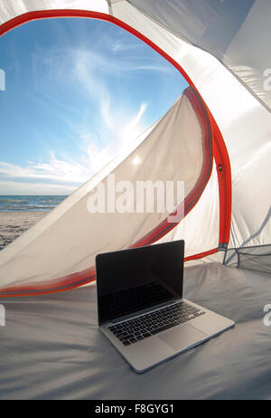 Laptop im Zelt am Strand Stockfoto