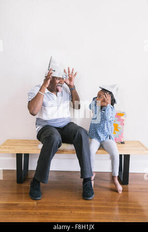 African American Großvater und Enkelin spielen auf Bank Stockfoto