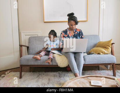 African American Mutter und Tochter im Wohnzimmer entspannen Stockfoto