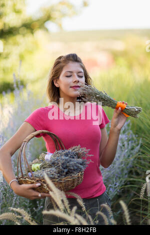 Gemischte Rassen Frau duftende Blumen im Garten Stockfoto