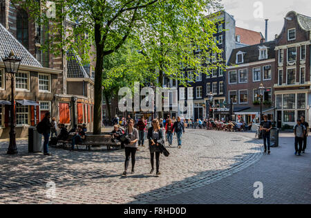 Menschen zu Fuß entlang einer von vielen Straßen Amsterdams, von denen einige mitlaufen, ist vielen Grachten in Holland Stockfoto