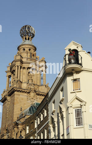 Eine Figur mit einem Bierfass auf dem Dach des Chandos-Pub, neben der Welt des West End von London Coliseum Theatre in London. Stockfoto