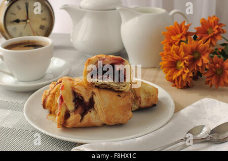 Ein Stück Strudel mit Kirschen mit einer Tasse Kaffee am Morgen Stockfoto