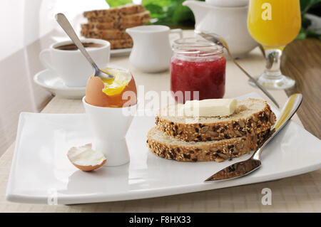 Wachsweiches Ei mit Haferflocken Brot mit Butter zum Frühstück Stockfoto