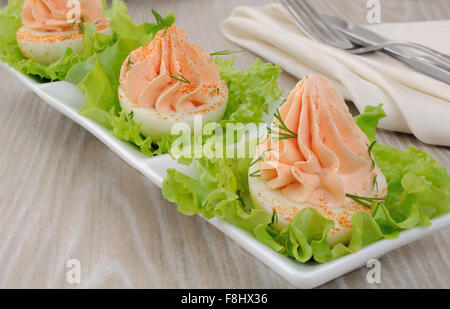 Eiern gefüllt mit Pastete Lachs mit Paprika in Kopfsalat Blätter Stockfoto