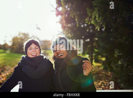 Zwei lächelnde Frauen auf Brücke im Park. Sonnig Stockfoto