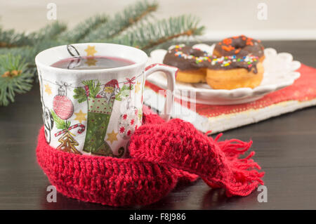 T-Stück in einer Serviettentechnik dekoriert Weihnachten Teetasse und selbstgemachte Donuts auf einem Teller Stockfoto