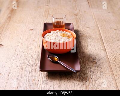 Frühstück Schüssel Haferbrei mit Honig auf Holz Stockfoto