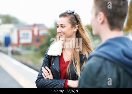 Junge Frau und junger Mann auf Bahnsteig Stockfoto