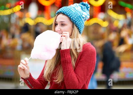Junge Frau essen Zuckerwatte Jahrmarkt, im freien Stockfoto