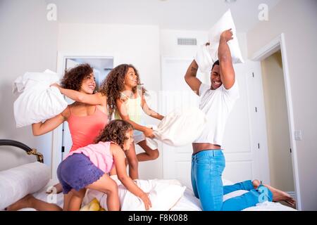 Familie Kissen Kämpfe am Bett, Lächeln Stockfoto