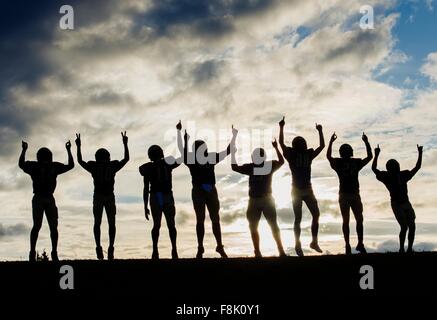 Silhouette der Gruppe von jungen amerikanischen Football-Spieler, feiern Stockfoto