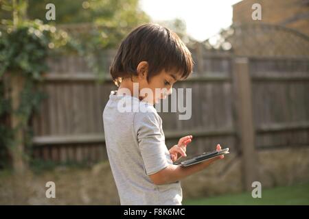 Seitenansicht eines jungen im Garten mit Blick nach unten mit digital-Tablette Stockfoto