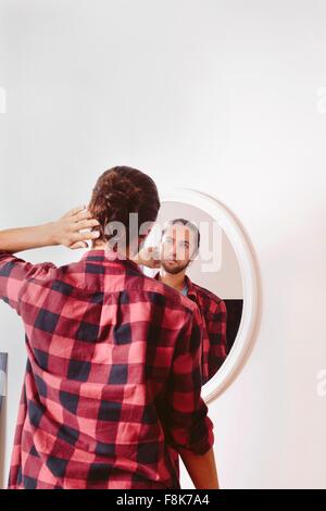 Junger Mann in Spiegel, Rückansicht Stockfoto