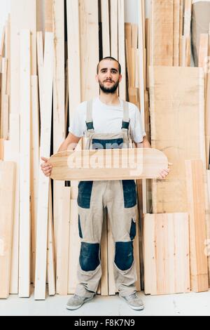 Mann mit Skateboard in Werkstatt Stockfoto