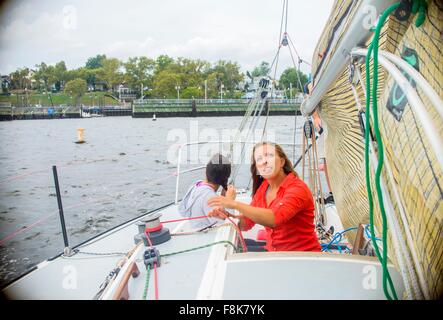 Junge Frau Anpassung Segel Segelboot, nachschlagen Stockfoto