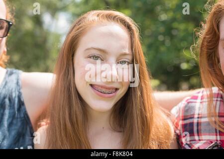 Porträt von roten Haaren junge Frau mit Zahnspangen, Blick auf die Kamera zu Lächeln Stockfoto