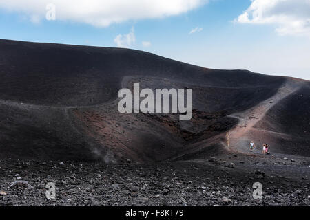 Die Menschen gehen auf die Krater der Eruption von 2002 bei einem Ausflug auf den Ätna. Stockfoto