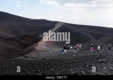 Die Menschen gehen auf die Krater der Eruption von 2002 bei einem Ausflug auf den Ätna. Stockfoto