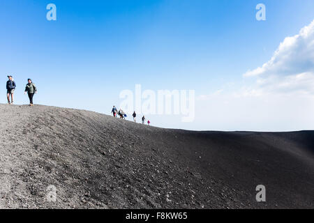 Die Menschen gehen auf die Krater der Eruption von 2002 bei einem Ausflug auf den Ätna. Stockfoto