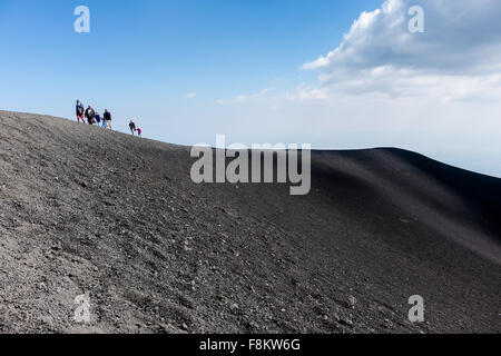 Die Menschen gehen auf die Krater der Eruption von 2002 bei einem Ausflug auf den Ätna. Stockfoto