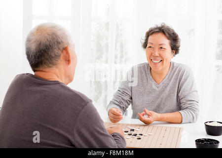 asiatische senior Brautpaar Schachspielen im Wohnzimmer Stockfoto