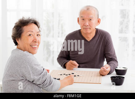 asiatische senior Brautpaar Schachspielen im Wohnzimmer Stockfoto