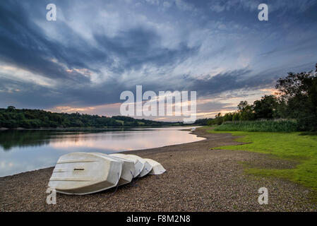 Sommer Sonnenuntergang über See Landschaft mit Freizeitboote am Ufer Stockfoto