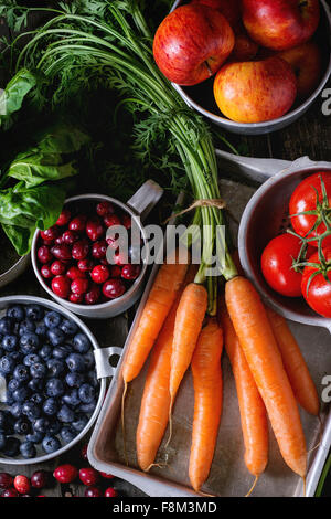Auswahl an frischem Obst, Gemüse und Beeren. Reihe von Karotten, Spinat, Tomaten und rote Äpfel, Heidelbeeren und Heidelbee Stockfoto