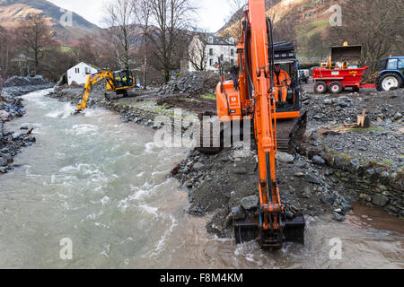 Glenridding, Cumbria, 10. Dezember 2015. Großbritannien Wetter.  Über Nacht Starkregen verursacht mehr Überschwemmungen als den Fluss, der durch das Dorf wieder übergelaufen.  Rettungsdienste hießen in der letzten Nacht, Menschen in Sicherheit zu helfen, als Volkspartei Besitzungen einschließlich Weihnachtsschmuck hinunter die Straße gewaschen wurden. Bagger wurden heute Morgen zur versuchen und Baggern Schutt aus dem Fluss in einem Versuch zu verhindern, dass weitere Überschwemmungen.  Im nahe gelegenen Patterdale könnte Beweis für die Kraft des Wassers vom Sturm Desmond auch gesehen werden, wo Hochwasser durch die Fahrbahn geplatzt. Bildnachweis: David Forster/Alamy Live Ne Stockfoto