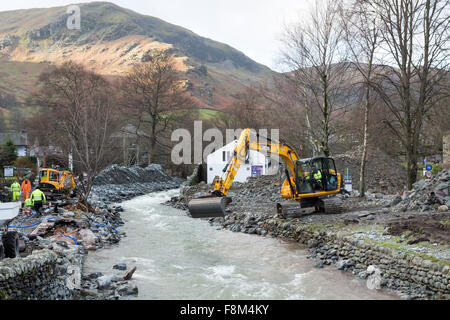 Glenridding, Cumbria, 10. Dezember 2015. Großbritannien Wetter.  Über Nacht Starkregen verursacht mehr Überschwemmungen als den Fluss, der durch das Dorf wieder übergelaufen.  Rettungsdienste hießen in der letzten Nacht, Menschen in Sicherheit zu helfen, als Volkspartei Besitzungen einschließlich Weihnachtsschmuck hinunter die Straße gewaschen wurden. Bagger wurden heute Morgen zur versuchen und Baggern Schutt aus dem Fluss in einem Versuch zu verhindern, dass weitere Überschwemmungen.  Im nahe gelegenen Patterdale könnte Beweis für die Kraft des Wassers vom Sturm Desmond auch gesehen werden, wo Hochwasser durch die Fahrbahn geplatzt. Bildnachweis: David Forster/Alamy Live Ne Stockfoto