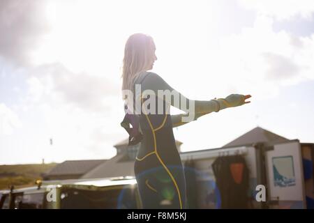 Surferin Neoprenanzug anziehen Stockfoto