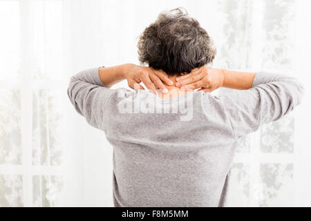 ältere Frau mit Nackenschmerzen Stockfoto